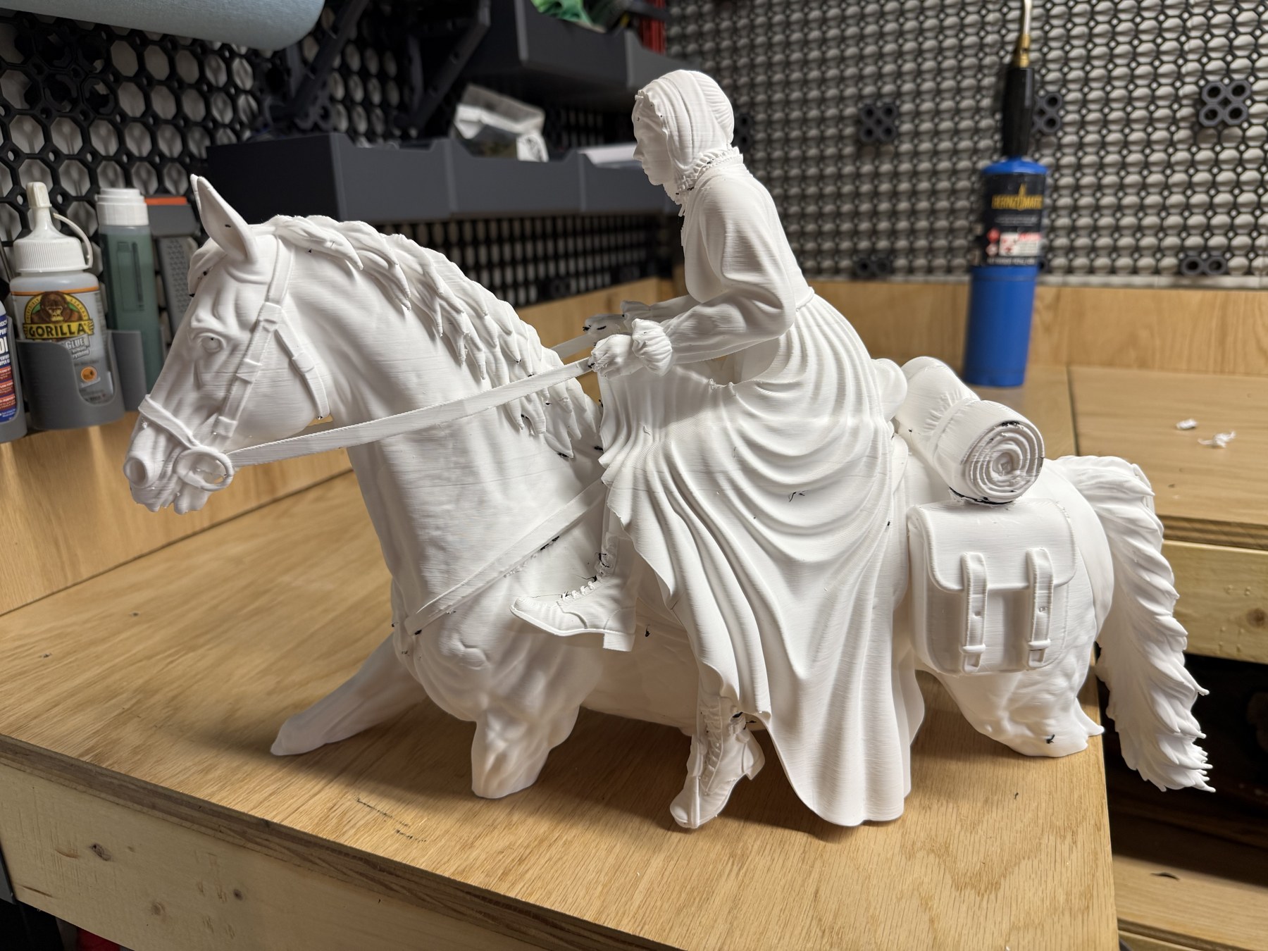 The printed horse and sidesaddle rider standing on the workbench, front left view.